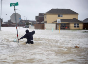 HOUSTON, TX - AUGUST 28: A person walks through a flooded street with a dog after the area was inundated with flooding from Hurricane Harvey on August 28, 2017 in Houston, Texas. Harvey, which made landfall north of Corpus Christi late Friday evening, is expected to dump upwards to 40 inches of rain in Texas over the next couple of days. (Photo by Joe Raedle/Getty Images)